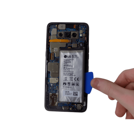 A hand holding a plastic pick, poised to access the battery of a Samsung Galaxy S8 device.
